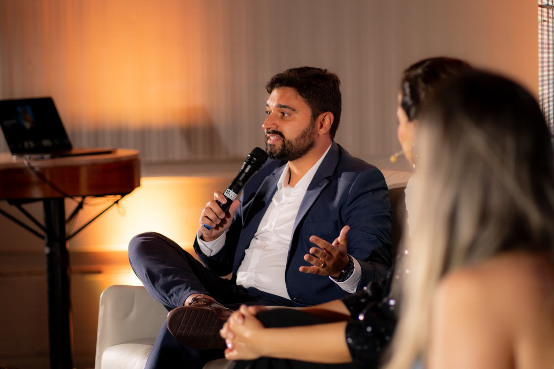 Participante fala ao microfone durante um painel do encontro presencial